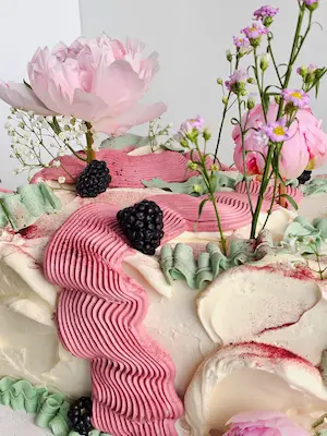 Floral cake with pink piping and blackberries